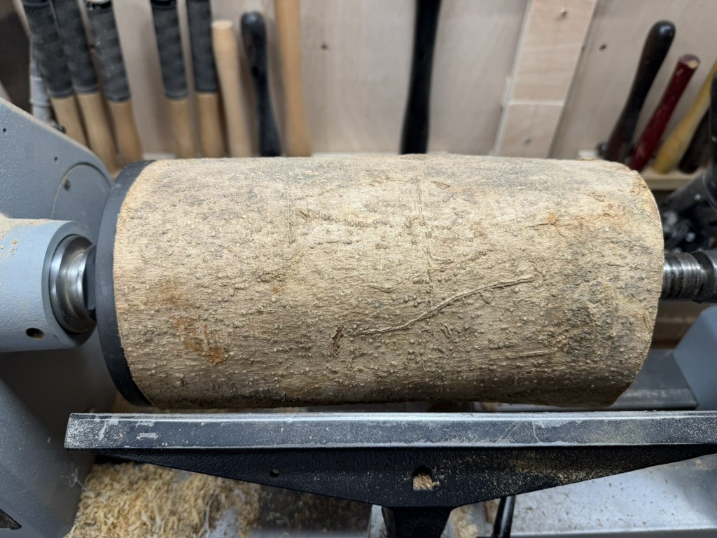 The blank on the lathe, bark still on