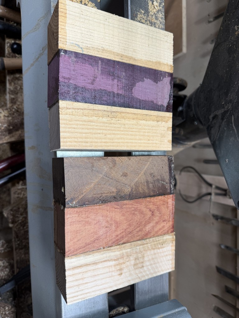 The glued-up blanks before turning: knob thorn, African rosewood and ash beneath, with the ash and purpleheart blank above